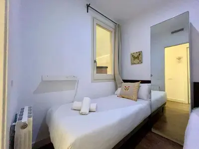 a white room with a bed with a window at BarcelonaForRent Tucson Suites in Barcelona