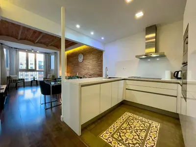 a kitchen with white cabinets and a dining room at BarcelonaForRent Tucson Suites in Barcelona