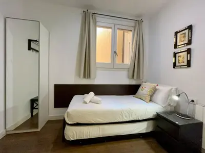 a small bedroom with a bed and a window at BarcelonaForRent Tucson Suites in Barcelona