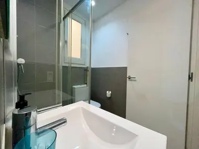 a white bathroom with a sink and a mirror at BarcelonaForRent Tucson Suites in Barcelona