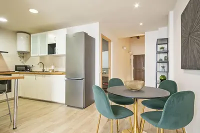 a kitchen with a table and chairs and a refrigerator at Alcam Galileu in Barcelona