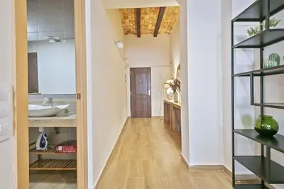 a hallway with a bathroom with a sink and a mirror at Alcam Galileu in Barcelona
