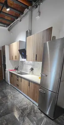 a kitchen with a stainless steel refrigerator and wooden cabinets at Beautiful Appartment in Martorell (Barcelona) in Martorell