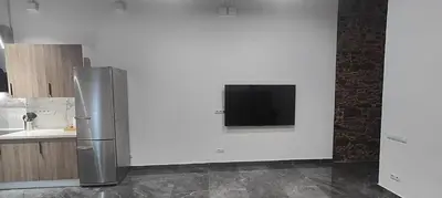 a refrigerator in a kitchen with a tv on a wall at Beautiful Appartment in Martorell (Barcelona) in Martorell