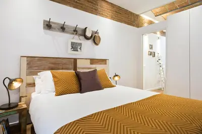 a bedroom with a large bed with yellow and white at Charming Parallel in Barcelona