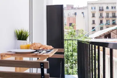 a table with a plate of food on a balcony at Charming Parallel in Barcelona