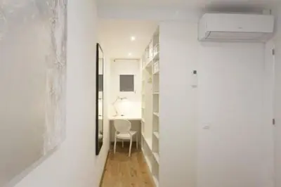 a hallway with white walls and a table and a mirror at Designer Apt near FIRA Balcony 5PPWIFISMART TV by MyRentalHost in Hospitalet de Llobregat