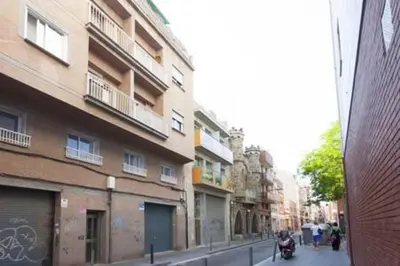 a street with buildings and a person on a scooter at Designer Apt near FIRA Balcony 5PPWIFISMART TV by MyRentalHost in Hospitalet de Llobregat