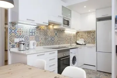 a kitchen with white appliances and a table and chairs at Designer Apt near FIRA Balcony 5PPWIFISMART TV by MyRentalHost in Hospitalet de Llobregat