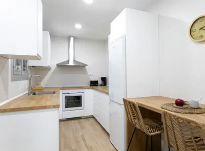 a kitchen with white cabinets and a counter top at Great Eixample Apartment in Barcelona