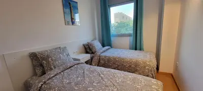 a bedroom with a bed and a chair and a window at Magnífica Isla de la playa Fórum y CCIB in Sant Adria de Besos