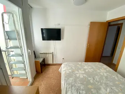 a bedroom with a bed and a tv on the wall at Big Family Terrassa Parking and noise free in Terrassa