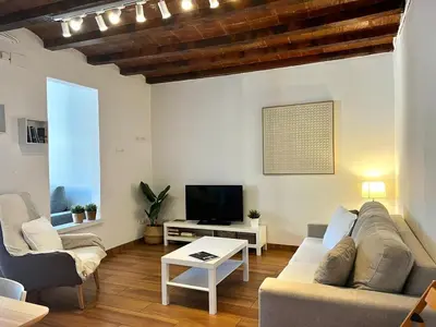 a living room with a couch and a tv at Bright & Spacious Family Flat in Central Barcelona in Barcelona