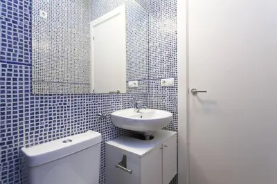a bathroom with a sink and a toilet and a mirror at Bright & Spacious Family Flat in Central Barcelona in Barcelona