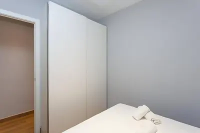 a white room with a bed and a mirror at Bright & Spacious Family Flat in Central Barcelona in Barcelona