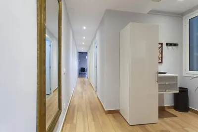 a hallway with white walls and a large mirror at Bright & Spacious Family Flat in Central Barcelona in Barcelona