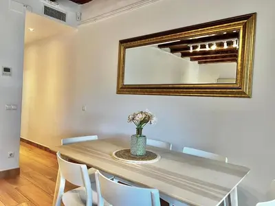 a dining room with a table with chairs and a mirror at Bright & Spacious Family Flat in Central Barcelona in Barcelona