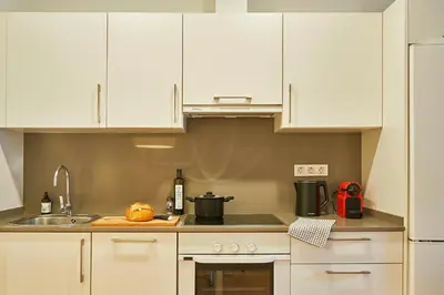 a kitchen with white cabinets and a sink at Catalan Comfort near Sagrada Familia by MyRentalHost in Barcelona