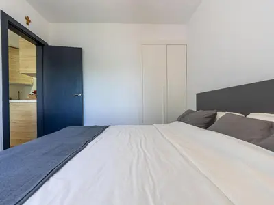 a bedroom with a large bed and a blue door at Apartment Zafiro by Interhome in Cubelles