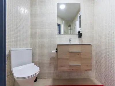 a bathroom with a toilet and a sink and a mirror at Apartment Zafiro by Interhome in Cubelles