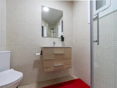 a bathroom with a sink and a toilet and a mirror at Apartment Zafiro by Interhome in Cubelles