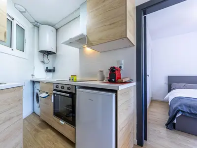 a small kitchen with a stove and a bed at Apartment Zafiro by Interhome in Cubelles