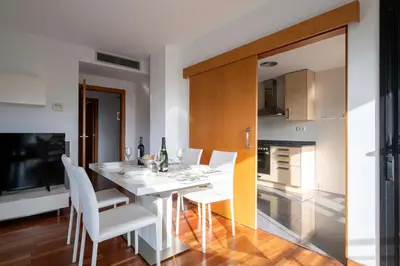 a dining room with a white table and white chairs at Apartment close to Diagonal Beach in Barcelona