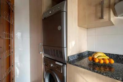 a kitchen with a dishwasher and a bowl of fruit at Apartment close to Diagonal Beach in Barcelona