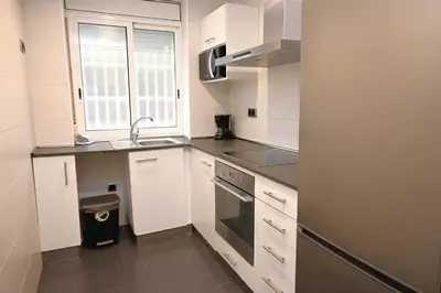 a small kitchen with white cabinets and a sink at Homenfun Barcelona Guinardó Hospital Sant Pau in Barcelona