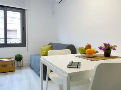 a white dining room table with a bowl of fruit on it at MarBarcelona Apartments Mas in Hospitalet de Llobregat