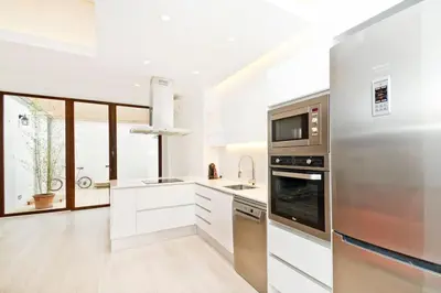 a kitchen with stainless steel appliances and a large window at Roós, design loft near the sea. in Barcelona
