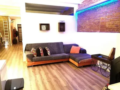 a living room with a couch and a brick wall at Roós, design loft near the sea. in Barcelona
