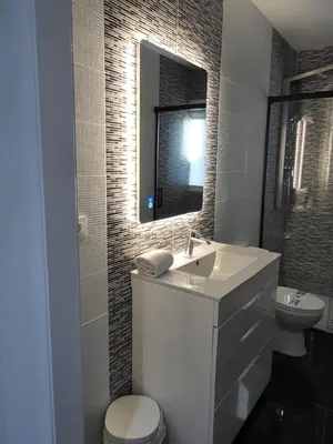 a bathroom with a sink and a toilet and a mirror at VILLA 5 PLAYA A 2 MINUTOS in Castelldefels