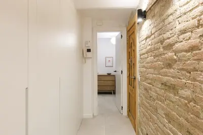 a hallway with a brick wall and a bathroom at Stylish Apartment near Plaça España in Barcelona