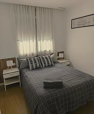 a bedroom with a bed and two night stands at Apartamento P1 30min Sagrada Familia, 10 min playa in Badalona