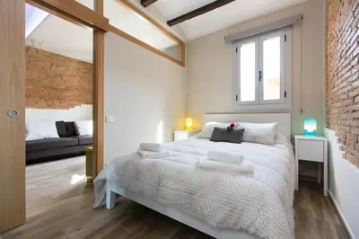 a bedroom with a large white bed and a couch at Stay Barcelona Charming Gracia in Barcelona