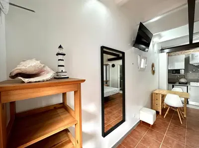 a small room with a mirror and a kitchen at Nuevos Apartamentos frente al mar y a la playa in Castelldefels