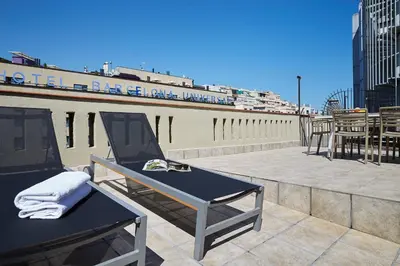 a patio with a table and chairs on a roof at AB Paral·lel Spacious Apartments in Barcelona