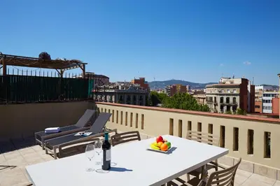 a white table with a bowl of fruit on a balcony at AB Paral·lel Spacious Apartments in Barcelona