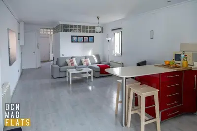 a kitchen and living room with a couch and a table at Bcn - Poble Nou in Barcelona