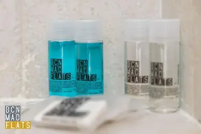 three bottles of toothpaste and a remote control on a sink at Bcn - Poble Nou in Barcelona