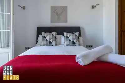 a bedroom with a large bed with red blanket at Bcn - Poble Nou in Barcelona