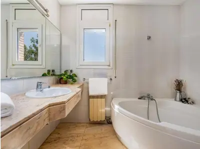 a white bathroom with a tub and a sink at MAGNÍFICA RESIDENCIA in Masnou