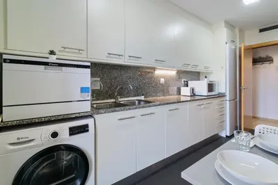 a white kitchen with a washing machine and a sink at Fira Suites - Habitaciones privadas en Apartamento compartido in Hospitalet de Llobregat