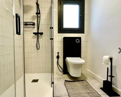 a bathroom with a toilet and a glass shower at Casa Brisa Boutique Guest House - Gay Men Only in Sant Pere de Ribes