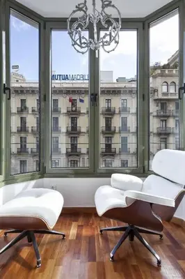 a room with two white chairs and a large window at Canela Homes BARCELONA UNIVERSITAT in Barcelona