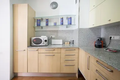 a kitchen with white cabinets and a microwave on the counter at Canela Homes BARCELONA UNIVERSITAT in Barcelona
