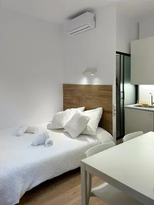 a bedroom with a white bed and a table at SD Habitación céntrica con baño y Kitchenette in Terrassa
