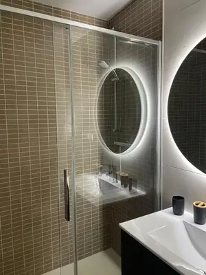 a bathroom with a shower and a sink and a mirror at Luminoso dúplex con parking in Terrassa