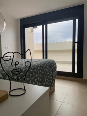a room with a bed and a view of the beach at Luminoso dúplex con parking in Terrassa